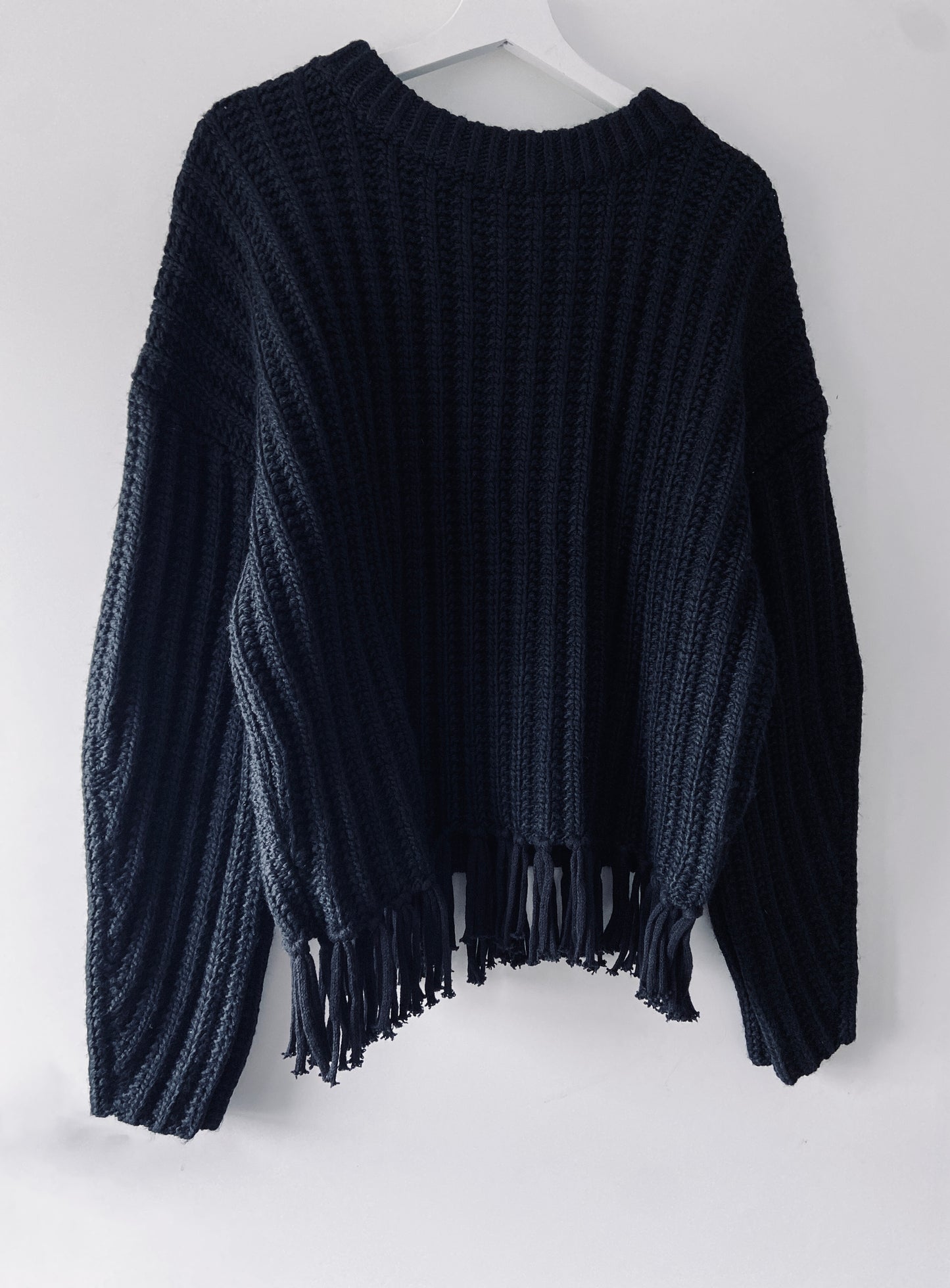 Black knitted ribbed sweater with fringes