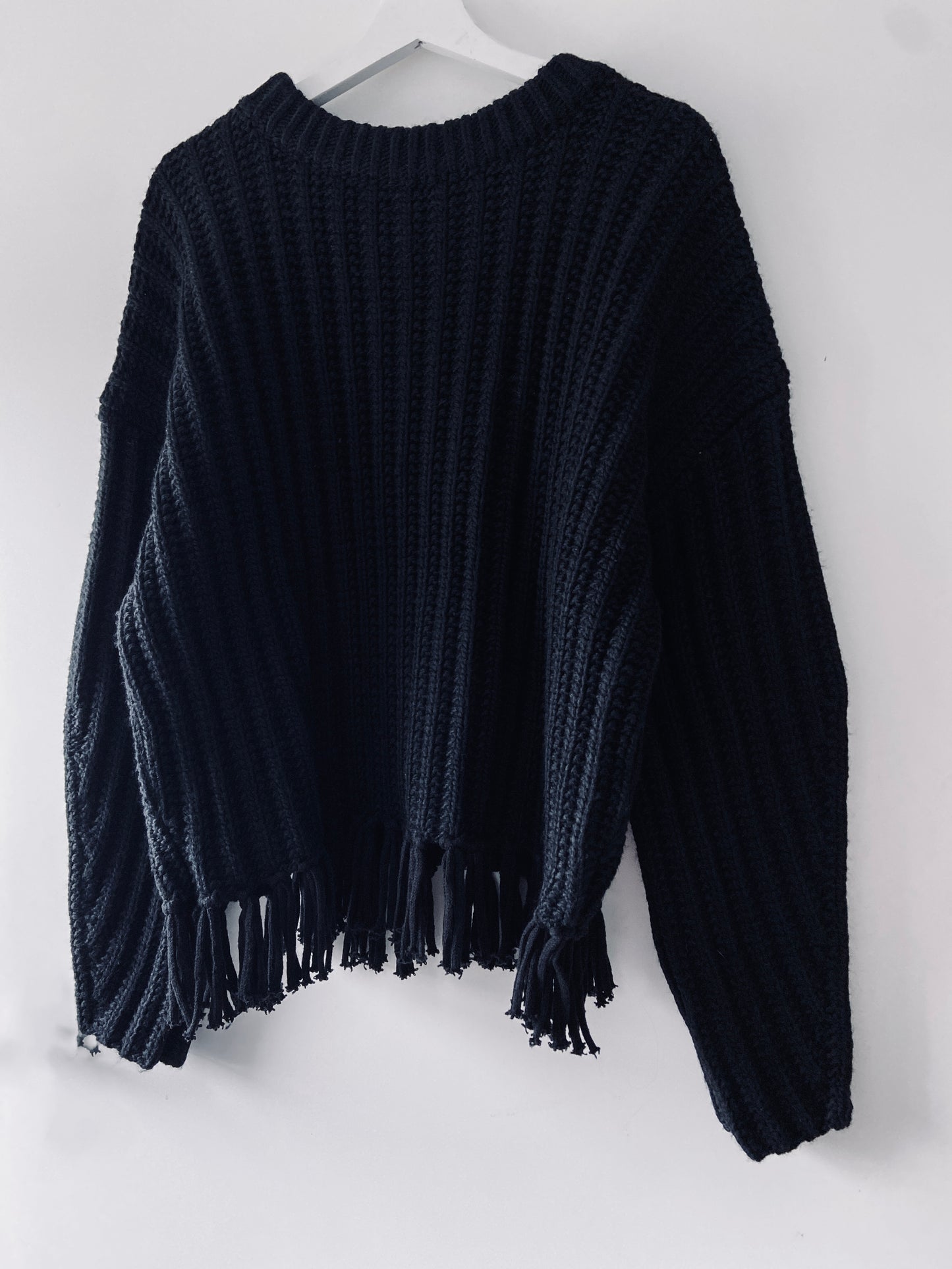 Black knitted ribbed sweater with fringes